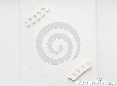 Pedicure finger separator on a white towel. Personal care at home Stock Photo