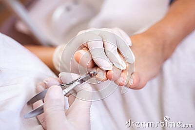 Pedicure salon employee using nail nippers Stock Photo