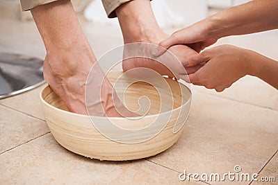 Pedicurist cleansing customer feet Stock Photo