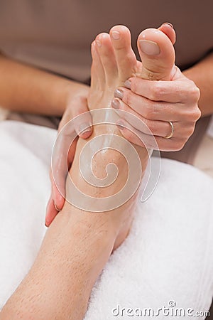 Pedicurist massaging customers foot Stock Photo