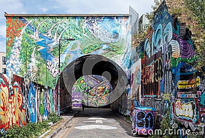 Pedley Street Arch, Shoreditch, East London. Pedestrian Alleyway under railway line near Brick Lane, covered in colourful graffiti Editorial Stock Photo