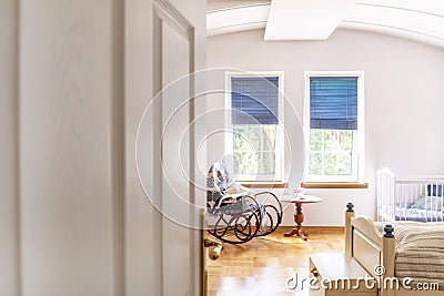 A peek through a half open door into a bedroom and baby`s room m Stock Photo