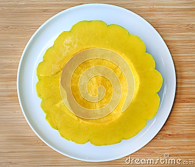 Peel and dissect pumpkin in white plate against wood background, cross section Stock Photo