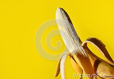 Peel the Deliciousness: Fresh Peeled Banana on Yellow Background Stock Photo