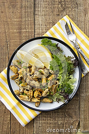 Peeled mussels with fresh lemom. Healthy seafood, natural sunlight, wooden rustic table Stock Photo