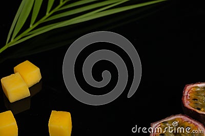 Peeled pineapple, bamboo and passion fruit. Fresh Tropical Fruits. On a black background. Top view. Copy space Stock Photo