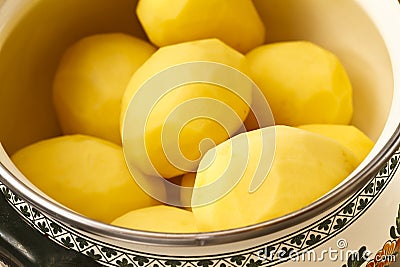 Peeled potatoes in bowl Stock Photo