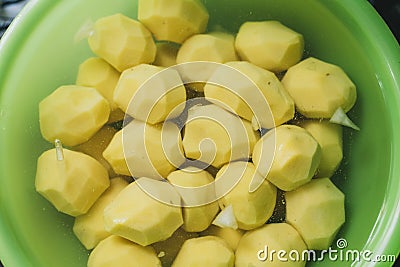 peeled potatoes lie in a green bowl with water. cooking homemade potatoes Stock Photo