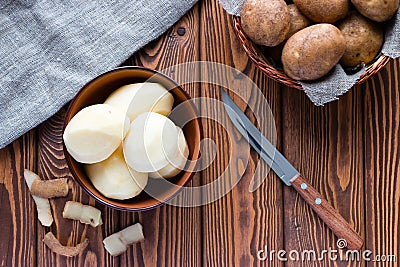 Peeled potatoes next to the skin Stock Photo