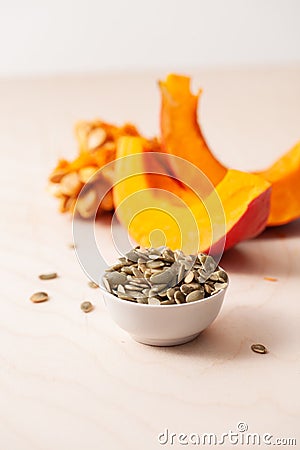 Peeled pumpkin seeds with pieces of fresh pumpkin Stock Photo