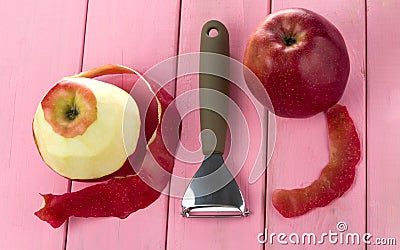 Peeler for cleaning fruits and vegetables with red apples and with peeled skin Stock Photo