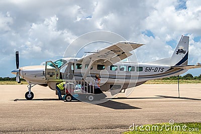 Pemba Domestic Airport apron with Auric Air local airline Cessna 208 Caravan aircraft loading baggage and preparing for flight. Editorial Stock Photo