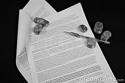 Pen and coins on open contract Stock Photo