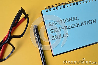 Pen, eyeglasses and notebook written with text EMOTIONAL SELF-REGULATIONS SKILLS Stock Photo