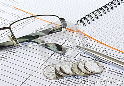 Pen on financial and accounting reports with coins stacks, glasses and calculator in background Stock Photo