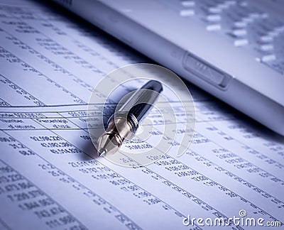 Pen and laptop on charts Stock Photo