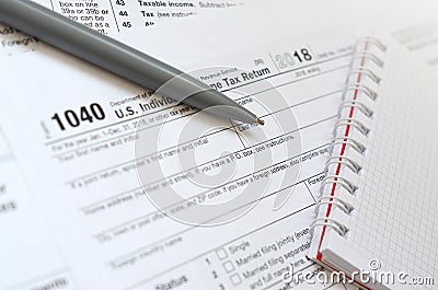 The pen and notebook is lies on the tax form 1040 U.S. Individua Editorial Stock Photo