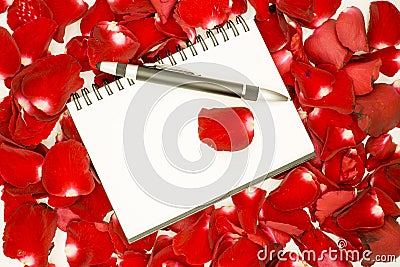 Pen on open notebook and rose petals Stock Photo