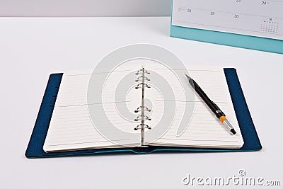 A pen is placed on a diary of blank notes, against the background.A pen is placed on a diary of blank notes, against the backgroun Stock Photo