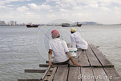 Penang, Malaysia, December 19 2017: Two Fishermen waiting for the catch of the day Editorial Stock Photo