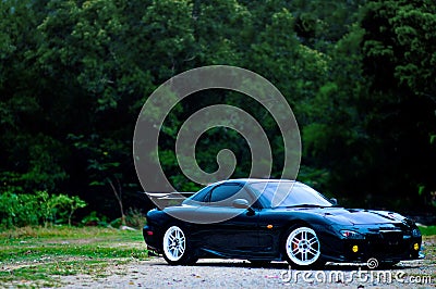 Penang, Malaysia - January 12, 2010 : View of a black Mazda RX-7 original specification with trees in the background at Gelugor, P Editorial Stock Photo