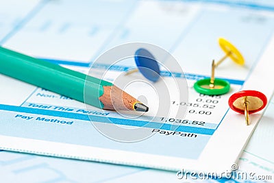 Pencil and colorful push pins on payroll Stock Photo