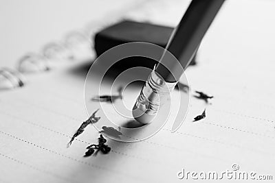 pencil eraser removing a written mistake on a piece of paper, de Stock Photo