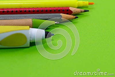 Pencil, marker, ball pen close up macro shot on vibrant green background Stock Photo