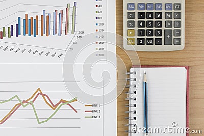 Pencil placed on notebook with calculator and graph on wood tab Stock Photo