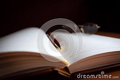 Pencil and reading glasses on a blank journal Stock Photo