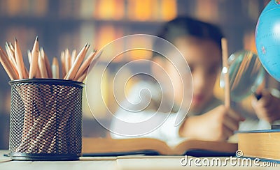 Pencils on a wooden table and asian child industrious is sitting at a desk . background. Educational background Stock Photo