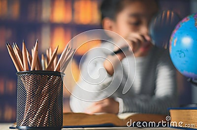 Pencils on a wooden table and asian child industrious is sitting at a desk . background. Educational background Stock Photo