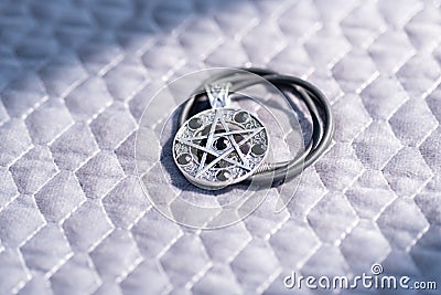 Pendant Magic Pentagram necklace silver and black color stainless steel shoot outside in a summer day Closeup. Stock Photo