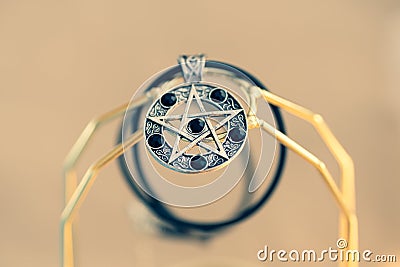 Pendant Magic Pentagram necklace silver and black color stainless steel shoot outside in a summer day Closeup. Stock Photo