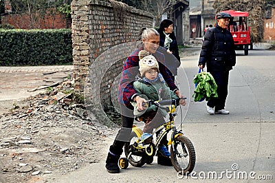 Pengzhou, China: Grandmother Teaching Child to Ride Bike Editorial Stock Photo
