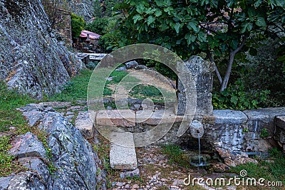 Old fountain from 1919 and a mossy stone with a writing, Penha Garcia, Portugal Editorial Stock Photo