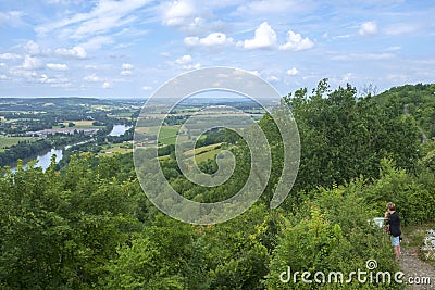 In early summer sunshine a woman considers the view over the Lot River and Valley from hilltop Penne d`Agenais Editorial Stock Photo