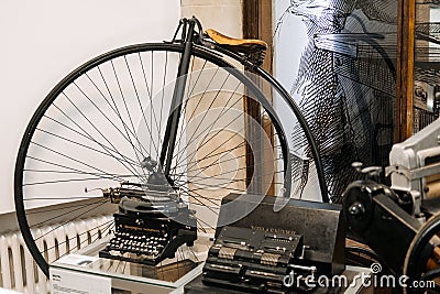 Warsaw, Poland - March 19, 2024. Penny-Farthing Bicycle and Vintage Typewriters Display Editorial Stock Photo