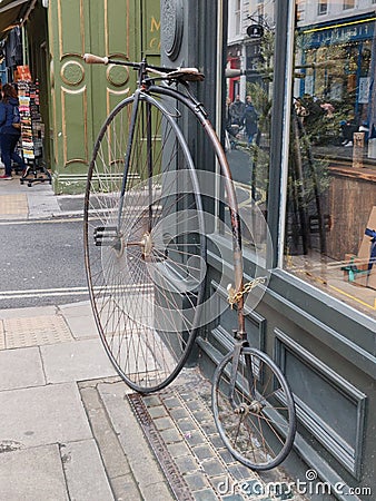 Penny farthing bicycle chained up parked outside a store in london Editorial Stock Photo