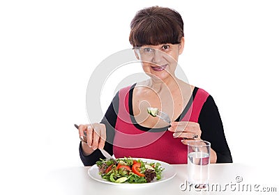 Pension age good looking smiling woman eating green salad Stock Photo