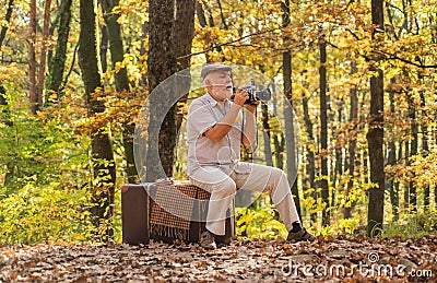 Pension hobby. Retro photographer. Used to manual settings. Old man shoot in nature. Landscape and nature photo shooting Stock Photo