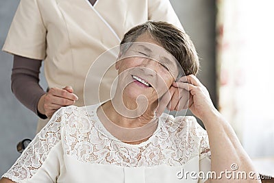 Pensioner holding hand of nurse Stock Photo