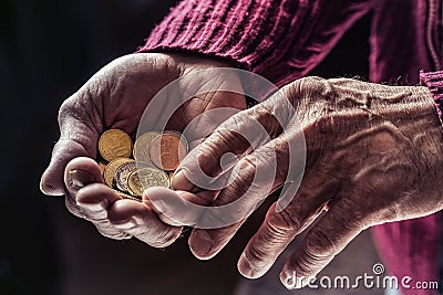 Pensioner man holding in hands euro coins. Theme of low pensions Stock Photo