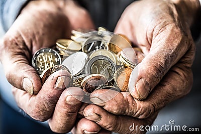 Pensioner man holding in hands euro coins. Theme of low pensions Stock Photo