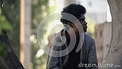 Pensive afro-american teenager sitting in abandoned place, hiding from parents Stock Photo