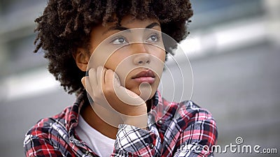 Pensive afro-american teenager thinking about future plans, choosing profession Stock Photo