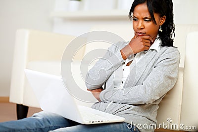 Pensive attractive woman sits on the floor Stock Photo