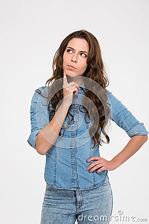 Pensive attractive young woman standing and thinking Stock Photo