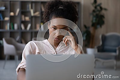 Pensive biracial woman work on laptop thinking Stock Photo