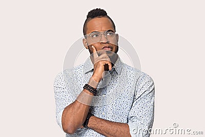 Pensive black male in glasses isolated on grey background thinking Stock Photo